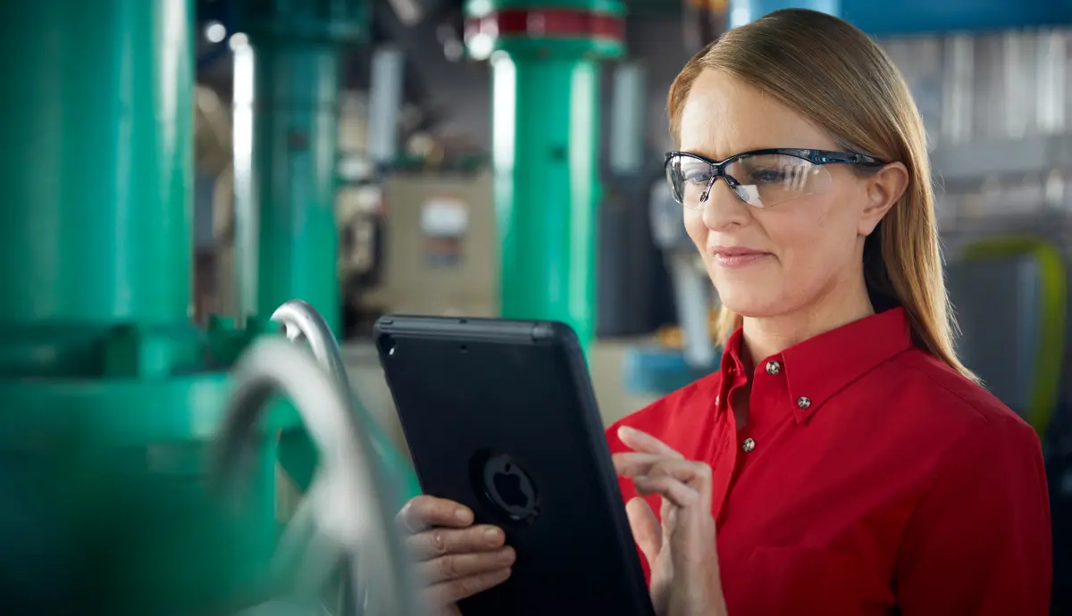 Transparent and Customized Healthcare Facilities Management Woman in red shirt and glasses using tablet in industrial setting
