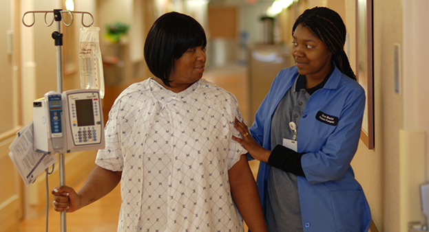 Patient and nurse walking down a corridor