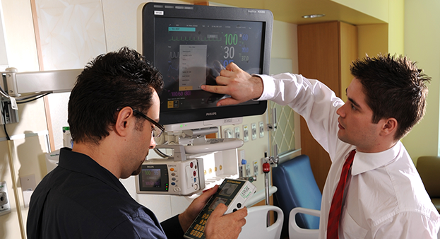 Two people inspect a medical device