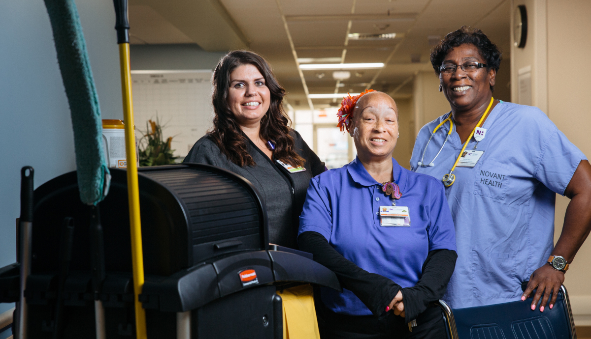 Crothall Healthcare team members smiling together in a hospital setting, working to support patient care.