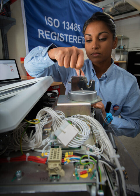 ISO 13485 registered technician inspects medical device components in laboratory
