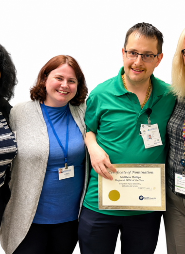 Matthew Phillips stands with colleagues while holding his Crothall Healthcare Regional GEM of the Year award certificate.
