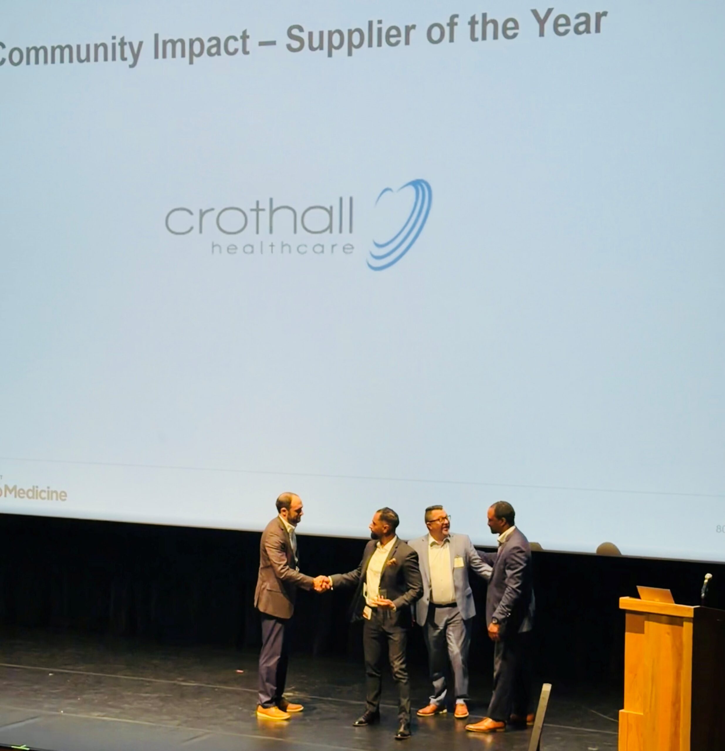Crothall team members accept the Supplier Community Impact Award onstage.
